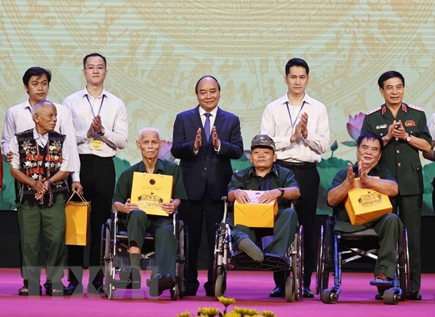 Chủ tịch nước Nguyễn Xuân Phúc và Đại tướng, Bộ trưởng Quốc phòng Phan Văn Giang trao quà cho người có công và các thương bệnh binh. Ảnh: Thống Nhất/TTXVN