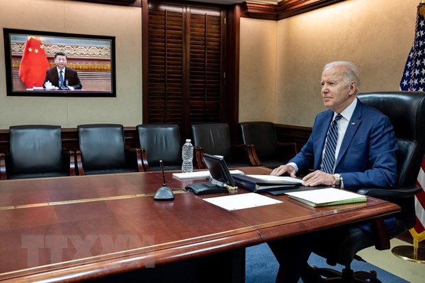 Tổng thống Mỹ Joe Biden và Chủ tịch Trung Quốc Tập Cận Bình (trên màn hình) tại cuộc họp trực tuyến ngày 18-3-2022. (Ảnh: AFP/TTXVN)