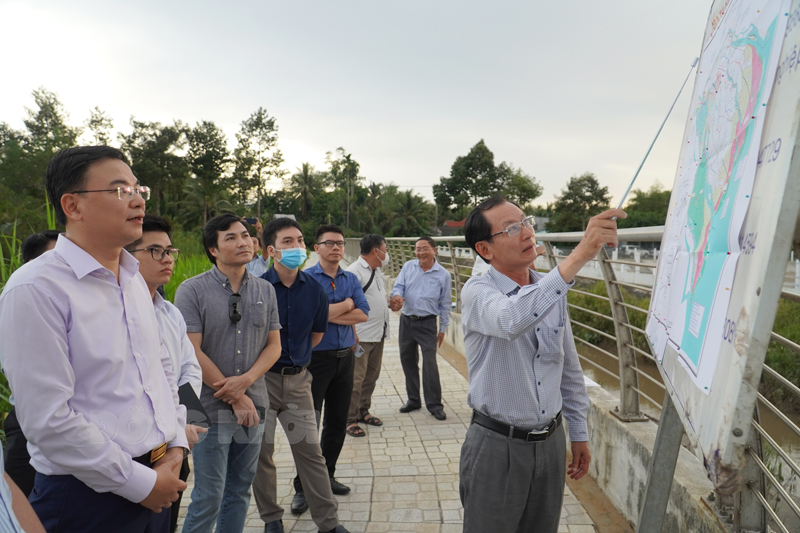 Thứ trưởng Bộ Ngoại giao Phạm Quang Hiệu (bìa trái) cùng đoàn công tác xem bản đồ thông tin Dự án công trình kè chống sạt lở sông Bến Tre. Ảnh: Phan Hân