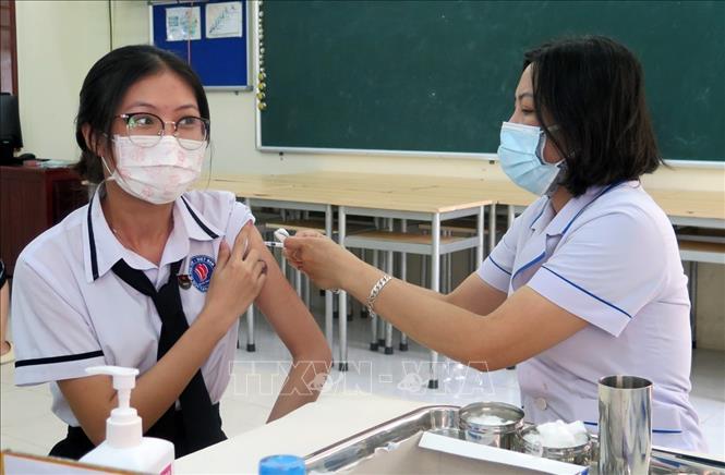 Ngày 21-8-2022, số ca mắc mới COVID-19 giảm xuống còn 1.561 ca Tiêm vaccine phòng COVID-19 cho các em học sinh. Ảnh: TTXVN.