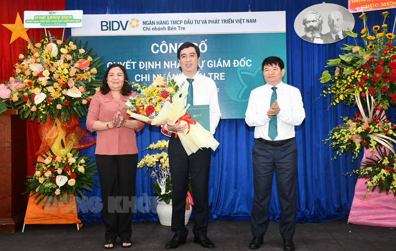 Phó tổng giám đốc BIDV Việt Nam Lê Trung Thành và Phó bí thư Thường trực Tỉnh ủy, Chủ tịch HĐND tỉnh Hồ Thị Hoàng yến trao hoa hoa chúc mừng.