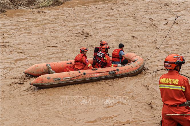 Nhân viên cứu hộ sơ tán người dân khỏi các khu vực ngập lụt ở tỉnh Cam Túc, Trung Quốc, ngày 16-7-2022. Ảnh tư liệu: AFP/TTXVN