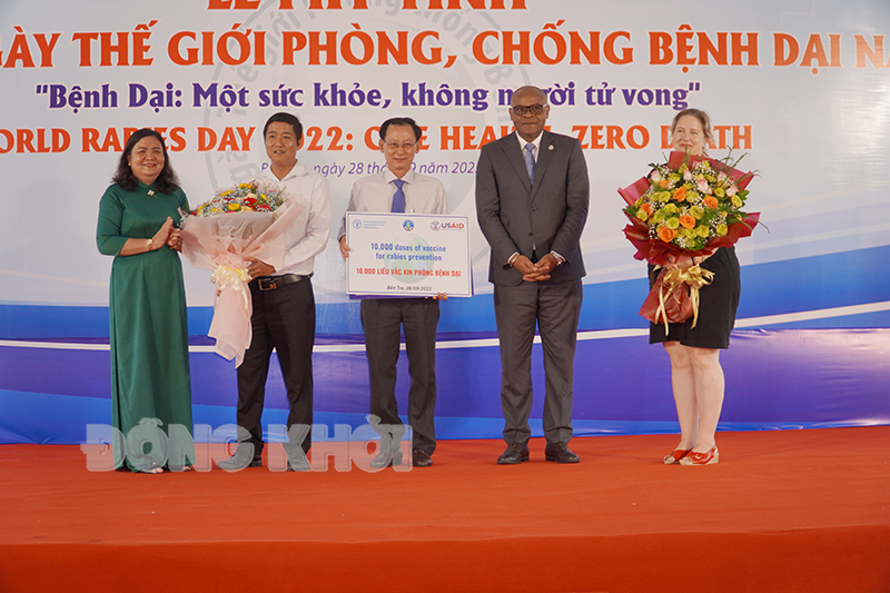 Phó chủ tịch UBND tỉnh Nguyễn Minh Cảnh tiếp nhận tài trợ vắc-xin và Phó bí thư Thường trực Tỉnh ủy - Chủ tịch HĐND tỉnh Hồ Thị Hoàng Yến trao hoa cảm ơn đơn vị tài trợ.