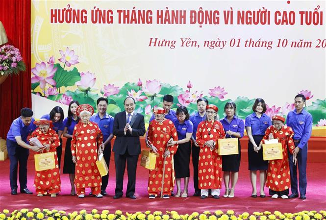 Chủ tịch nước Nguyễn Xuân Phúc tặng quà các cụ cao tuổi tại buổi lễ. Ảnh: Thống Nhất/TTXVN