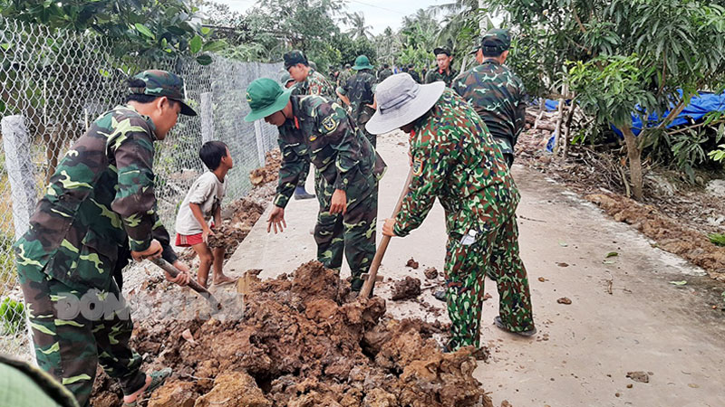 Cán bộ, chiến sĩ gia cố cống ấp Phú Thuận, xã Phú Mỹ (Mỏ Cày Bắc) trong Chương trình Hành quân xanh. Ảnh: Đặng Thạch