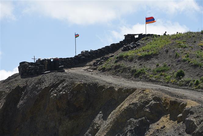 Quốc kỳ Azerbaijan (trái) và quốc kỳ Armenia tại trạm kiểm soát biên giới giữa hai nước ở làng Sotk (Armenia). Ảnh: AFP/TTXVN