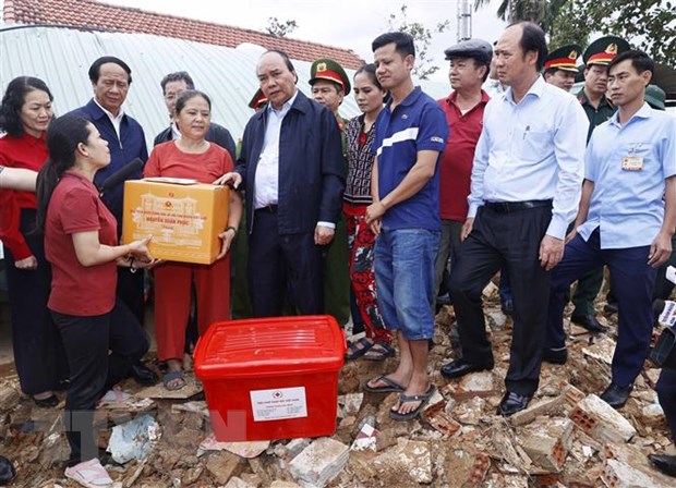 Chủ tịch nước Nguyễn Xuân Phúc và đoàn công tác tới thăm hỏi, động viên và tặng quà gia đình bà Đỗ Thị Thanh Hoa, ở thôn Thạch Nham Đông, xã Hòa Nhơn, huyện Hòa Vang, thành phố Đà Nẵng. Ảnh: Thống Nhất/TTXVN