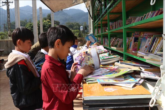 Các em học sinh vùng cao Sơn La được tiếp cận với nhiều loại sách báo bổ ích thông qua xe thư viện lưu động. Ảnh tư liệu: Hữu Quyết/TTXVN