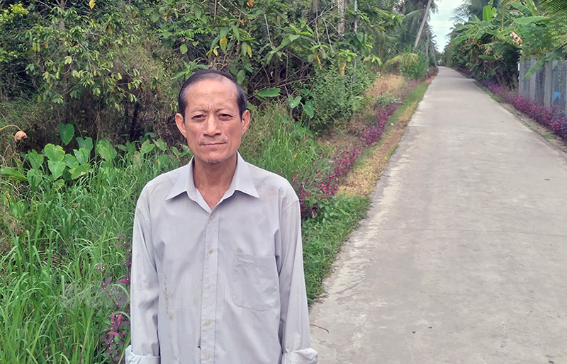 Cựu chiến binh Lê Văn Tho bên con đường bê-tông ấp Long Thuận, xã Sơn Phú (Giồng Trôm). Ảnh: Đ. Chính