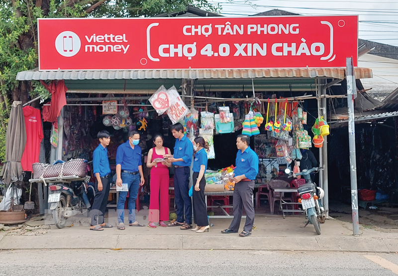 Đoàn viên, thanh niên tuyên truyền, vận động các tiểu thương chợ xã Tân Phong (Thạnh Phú) cài đặt và sử dụng các ứng dụng tiện ích trên điện thoại thông minh. Ảnh: Chương Đài