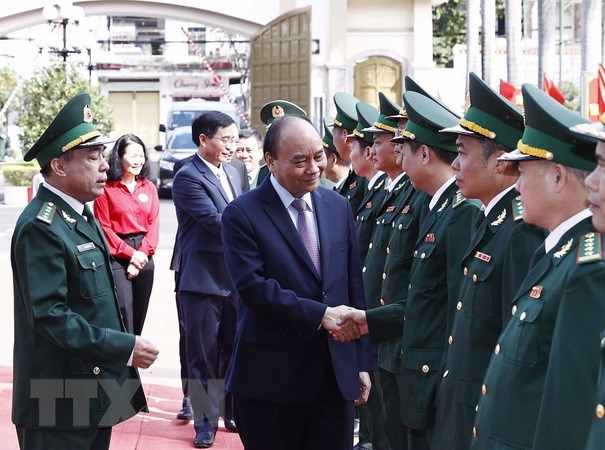 Cán bộ, chiến sỹ Bộ đội Biên phòng tỉnh Đắk Lắk đón Chủ tịch nước Nguyễn Xuân Phúc tới thăm, chúc Tết. (Ảnh: Thống Nhất/TTXVN)