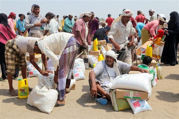 Người dân nhận hàng cứu trợ tại một trại tị nạn ở thành phố Hodeidah (Yemen) ngày 31-8-2022. (Ảnh: AFP/TTXVN)