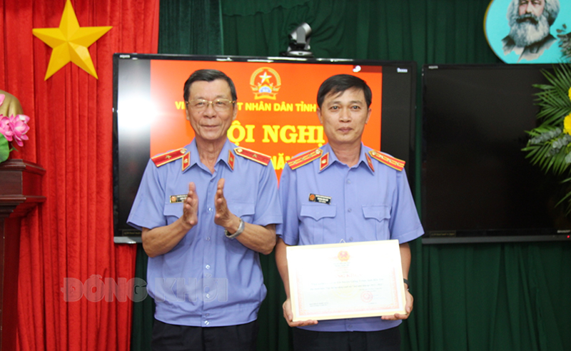 Viện trưởng Viện Kiểm sát nhân dân tỉnh Châu Văn Thơi (bên trái) trao bằng khen của Viện KSND tối cao cho đại diện lãnh đạo Viện KSND huyện Giồng Trôm về thành tích xuất sắc 2 năm liền (2021 - 2022).