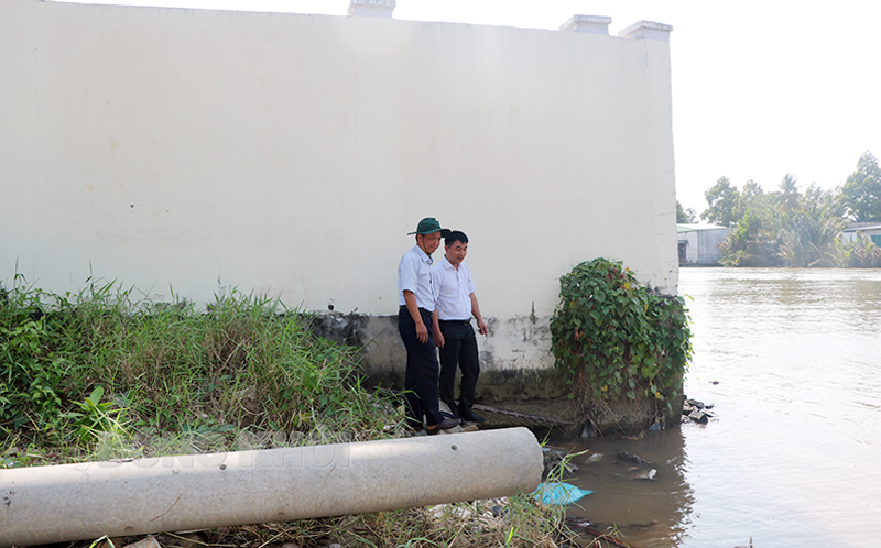 Vách tường trụ sở cơ quan Bảo hiểm xã hội huyện trơ trọi và ngập nước do ảnh hưởng sạt lở bờ sông Mỏ Cày. Ảnh: T.Thảo