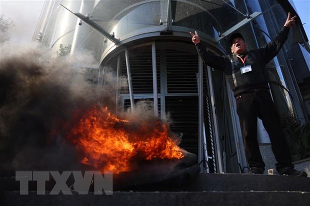 Người biểu tình đốt phá ngân hàng ở Beirut, Liban, ngày 16-2. (Ảnh: AFP/TTXVN)