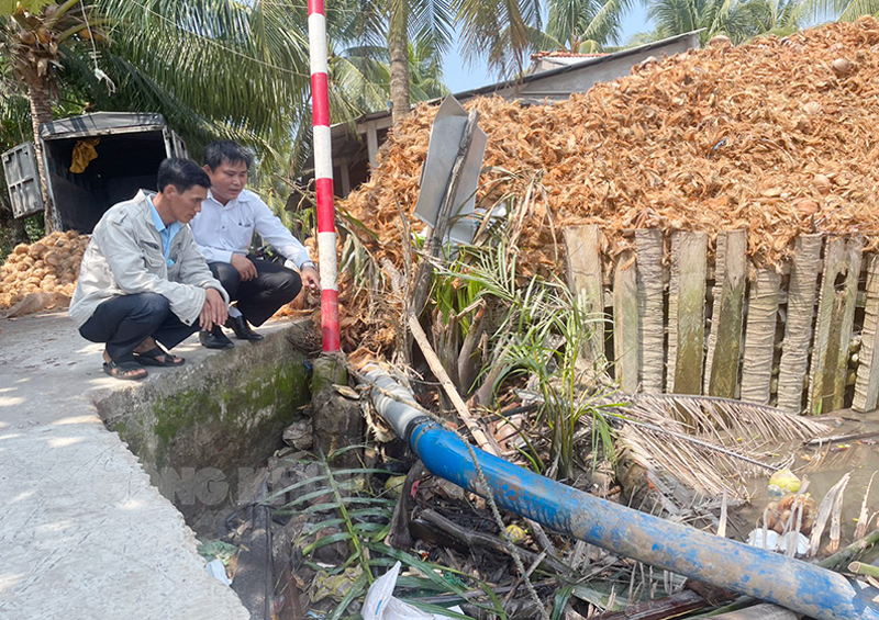 Giám đốc Trung tâm Nước sạch và Vệ sinh môi trường nông thôn Hạ Chí Điền kiểm tra đường ống dẫn nước từ sà lan vào Nhà máy nước Lương Phú (Giồng Trôm).