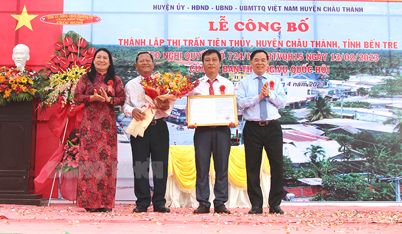 Chủ tịch UBND tỉnh Trần Ngọc Tam, Phó chủ tịch UBND tỉnh Nguyễn Thị Bé Mười trao Nghị quyết thành lập thị trấn Tiên Thủy và tặng hoa cho đại diện lãnh đạo địa phương.