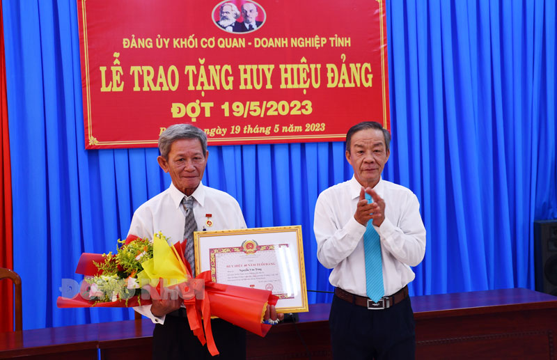 Bí thư Đảng ủy Khối Cơ quan - Doanh nghiệp Võ Văn Kiệt trao Huy hiệu 40 năm tuổi Đảng cho đồng chí Nguyễn Văn Tòng, Chi bộ Hội Nạn nhân chất độc da cam/dioxin.