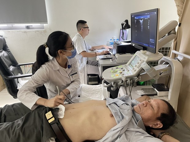 Bộ Y tế ban hành Thông tư quy định khung giá khám bệnh theo yêu cầu Nhân viên y tế thực hiện siêu âm ổ bụng cho một bệnh nhân. Ảnh: PV/Vietnam+