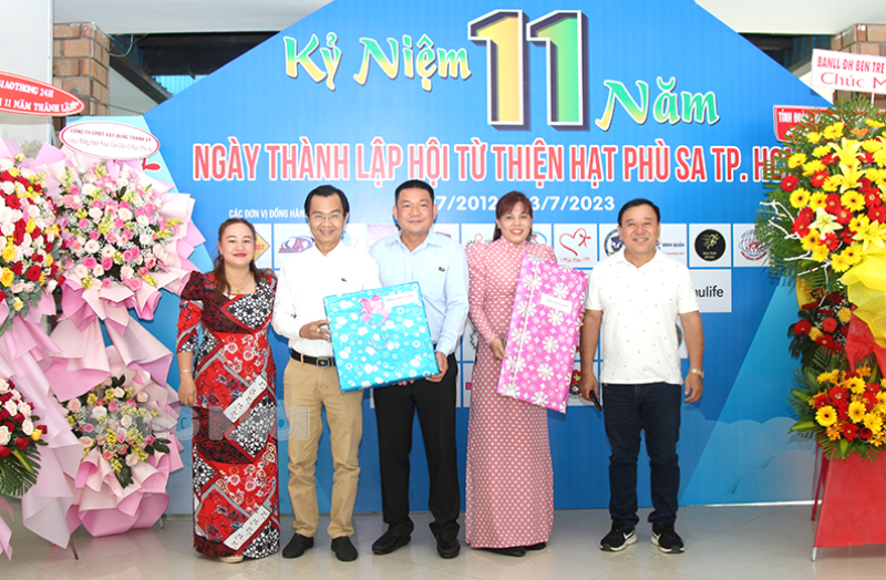 Hội Từ thiện Hạt Phù Sa TP. Hồ Chí Minh họp mặt kỷ niệm 11 năm ngày thành lập Phó tổng Biên tập Báo Đồng Khởi Nguyễn Văn Bảy (thứ 2, từ trái qua) trao quà tặng cho đại diện Hội HPS TP. Hồ Chí Minh.
