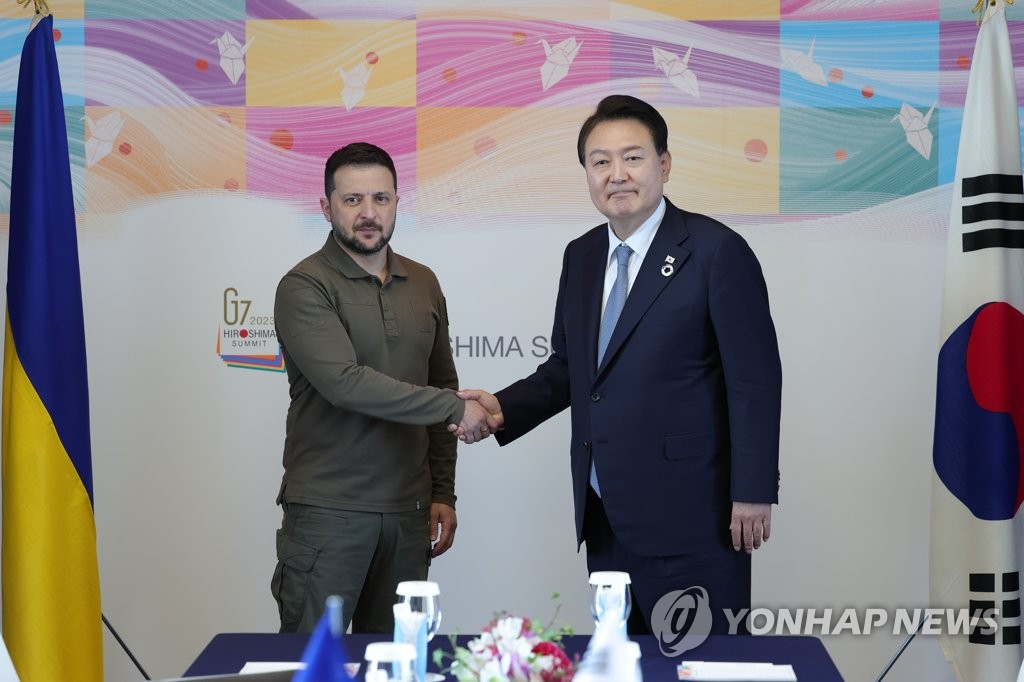 Tổng thống Hàn Quốc Yoon Suk Yeol (phải) bắt tay Tổng thống Ukraine Volodymyr Zelensky trong hội nghị thượng đỉnh ở Hiroshima, Nhật Bản ngày 21-5. Ảnh: Yonhap