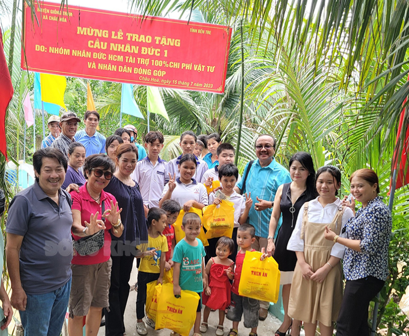 Người dân địa phương và đại diện nhà tài trợ chụp ảnh lưu niệm trước cầu Tổ 1.