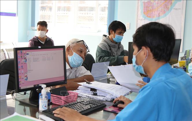 Những chính sách mới nổi bật có hiệu lực trong tháng 8 Cán bộ UBND phường Hiệp Bình Chánh, thành phố Thủ Đức giải quyết hồ sơ cho người dân. Ảnh: Xuân Tình/TTXVN