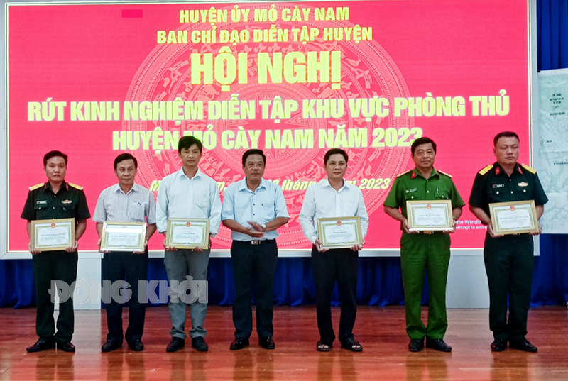 Mỏ Cày Nam hội nghị rút kinh nghiệm diễn tập khu vực phòng thủ huyện năm 2023 Phó bí thư Thường trực Huyện ủy Nguyễn Văn Nhạn tặng giấy khen cho các tập thể có thành tích xuất sắc trong diễn tập.