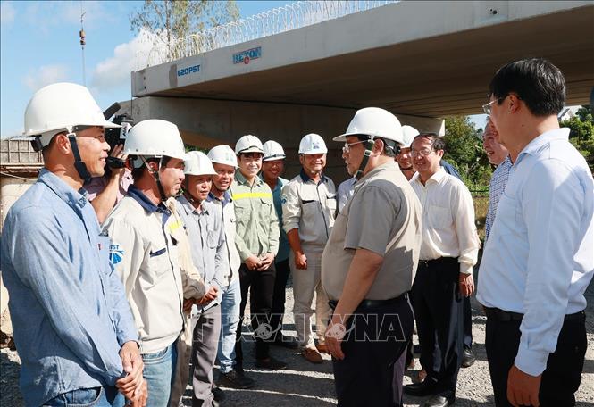 Thủ tướng Phạm Minh Chính với công nhân thi công Dự án nâng cấp quốc lộ 30 đoạn Cao Lãnh - Hồng Ngự. Ảnh: Dương Giang/TTXVN