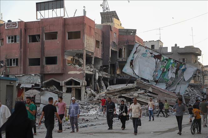 Các nước phương Tây ra tuyên bố chung về xung đột Hamas - Israel Người dân di chuyển qua những tòa nhà bị phá hủy sau các cuộc không kích của Israel tại Dải Gaza ngày 16-10-2023. Ảnh: THX/TTXVN