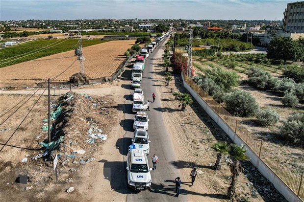 Đoàn xe tải chở hàng viện trợ di chuyển từ Ai Cập qua cửa khẩu Rafah vào Dải Gaza ngày 21-10. (Ảnh: AFP/TTXVN)