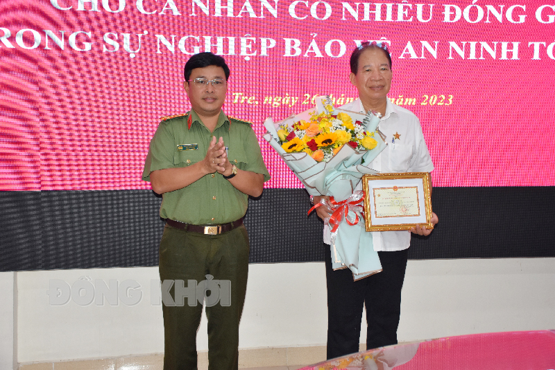 Đại tá Phạm Thanh Tùng trao Kỷ niệm chương cho ông Vũ Hồng Dụ.