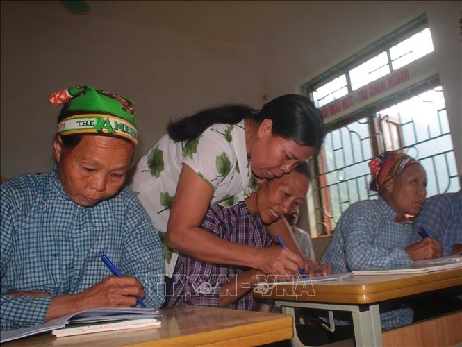 Cô giáo hướng dẫn học viên viết chữ tại lớp xóa mù chữ ở Lũng Chuống, xã Nội Thôn, huyện Hà Quảng, tỉnh Cao Bằng. Ảnh: Chu Hiệu/TTXVN