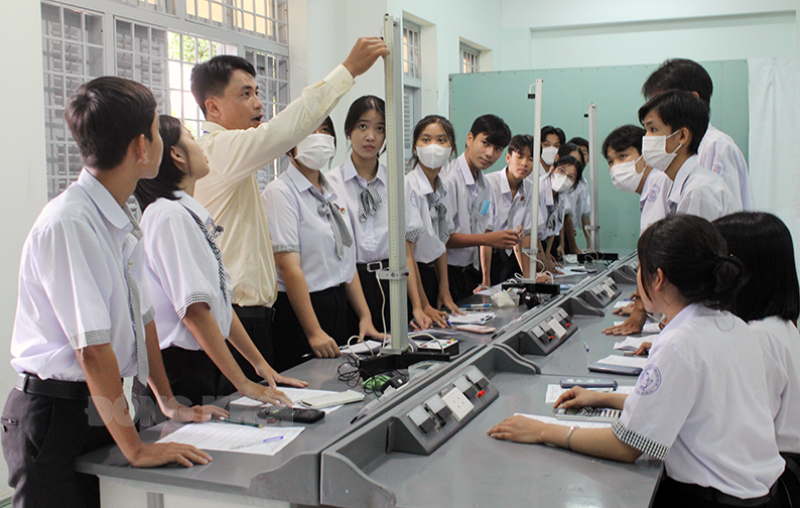 Thầy Lương Tấn Lộc đang hướng dẫn học sinh thực hành môn Vật lý.