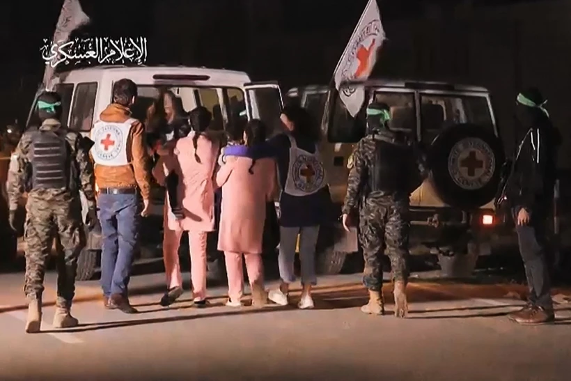 Hình ảnh chụp qua video: Các tay súng Hamas bàn giao nhóm con tin người Israel được trả tự do cho Ủy ban Chữ thập Đỏ Quốc tế, tại Dải Gaza ngày 27-11. (Ảnh: AFP/TTXVN)