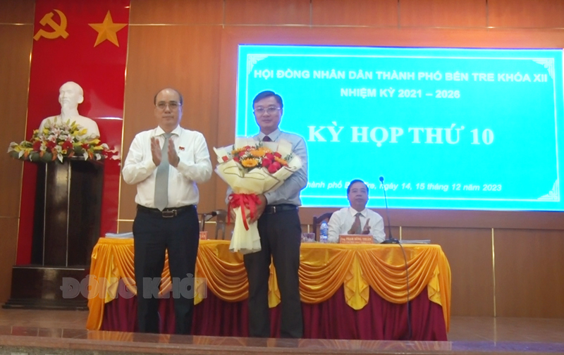 Bí thư Thành ủy - Chủ tịch HĐND thành phố Nguyễn Văn Tuấn tặng hoa chúc mừng ông Ngô Văn Lam.