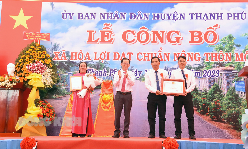 Phó chủ tịch UBND tỉnh Nguyễn Minh Cảnh trao bằng công nhận xã nông thôn mới cho lãnh đạo xã Hòa Lợi.