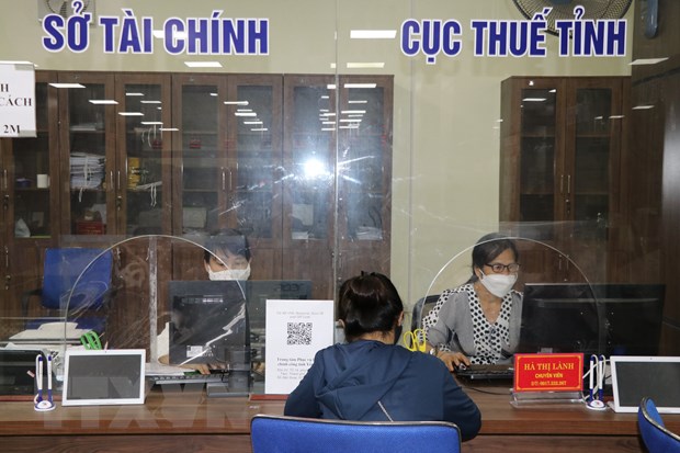Nghị quyết về áp dụng thuế thu nhập doanh nghiệp bổ sung Cán bộ Sở Tài chính và Cục Thuế tỉnh Yên Bái hướng dẫn các thủ tục hành chính tại Trung tâm hành chính công của tỉnh. Ảnh minh họa: Tiến Khánh/TTXVN