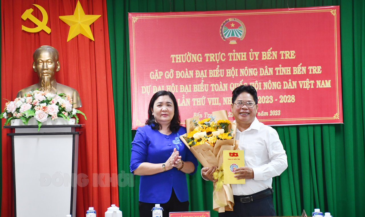 Quyền Bí thư Tỉnh ủy - Chủ tịch HĐND tỉnh Hồ Thị Hoàng Yến trao hoa và quà chúc mừng đoàn dự đại hội Trung ương Hội nông dân Việt Nam.