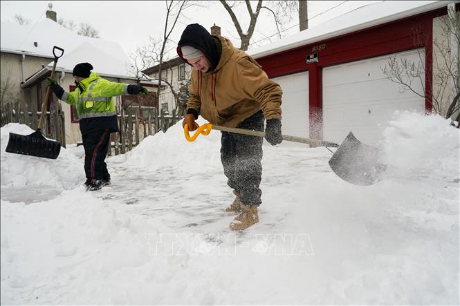 Người dân dọn tuyết tại Minneapolis, bang Minnesota, Mỹ. Ảnh tư liệu: AFP/TTXVN