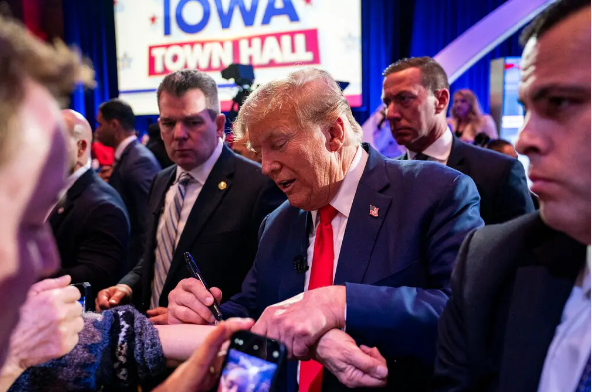 CNN dự báo cựu Tổng thống Trump chắc thắng trong bầu cử sơ bộ bang Iowa Ông Trump ký tên cho người ủng hộ ở Des Moines, bang Iowa. Ảnh: New York Times