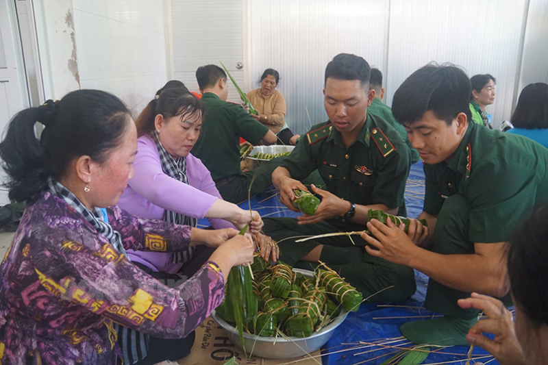 Cán bộ, hội viên phụ nữ các xã biển cùng các chiến sĩ Bộ đội Biên phòng Hàm Luông tham gia hội thi gói bánh tét.