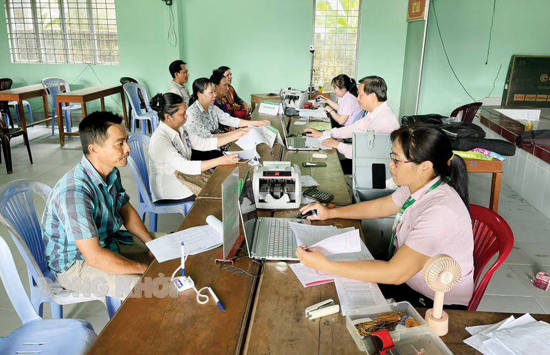 Cán bộ Phòng Giao dịch Ngân hàng Chính sách xã hội huyện Mỏ Cày Nam phục vụ người dân tại điểm giao dịch xã An Thới. Ảnh: Thanh tâm