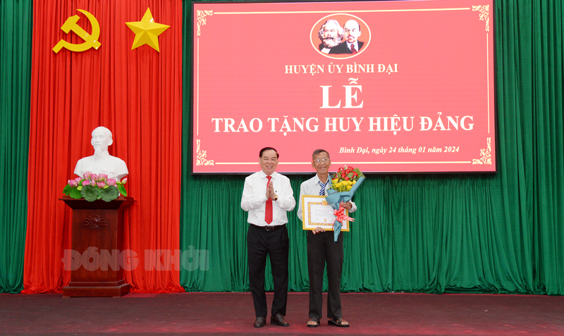 Phó bí thư Tỉnh ủy, Chủ tịch UBND tỉnhTrần Ngọc Tam- Bến Tre trao huy hiệu 60 năm tuổi đảng cho đồng chí Trần Văn Chiến. Ảnh: Sơn Tùng