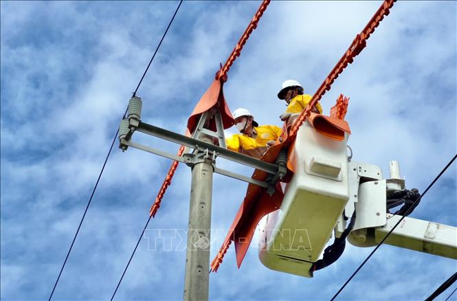 Nhân viên điện lực kiểm tra, sửa chữa trên đường dây nhằm đảm bảo cấp điện an toàn, ổn định. Ảnh: TTXVN phát