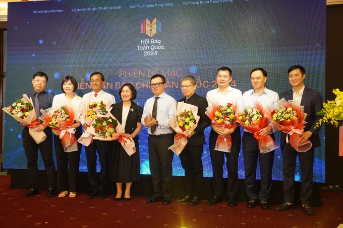 Báo chí cần tận dụng cơ hội trong kỷ nguyên số Chủ tịch Hội Nhà báo Việt Nam Lê Quốc Minh tặng hoa đến các đại biểu tham dự các diễn đàn.