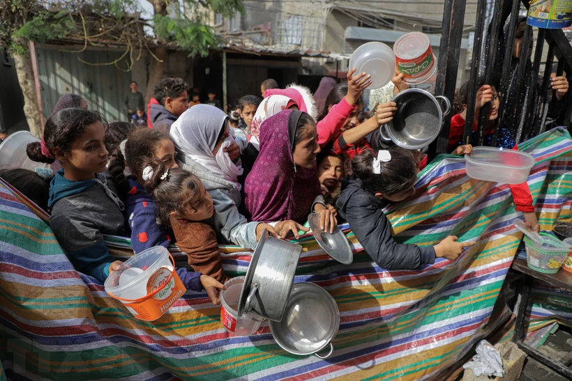 Người dân chờ được phát thực phẩm cứu trợ tại Rafah, Dải Gaza. (Ảnh: THX/TTXVN)