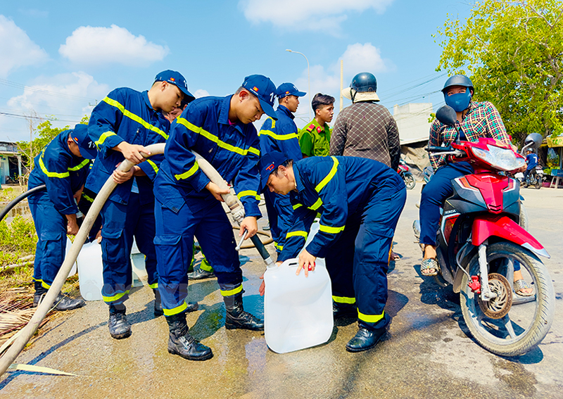 Cán bộ chiến sĩ Phòng Cảnh sát Phòng cháy, chữa cháy và cứu nạn, cứu hộ cấp nước ngọt cho người dân.