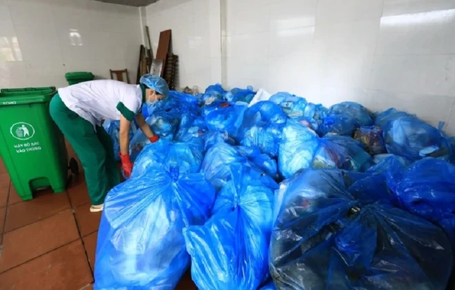 Bộ Y tế yêu cầu tăng cường quản lý nước thải, chất thải y tế Nhân viên vệ sinh sắp xếp rác thải sinh hoạt đã được phân loại theo túi nylon màu xanh. Ảnh: Thành Đạt/TTXVN