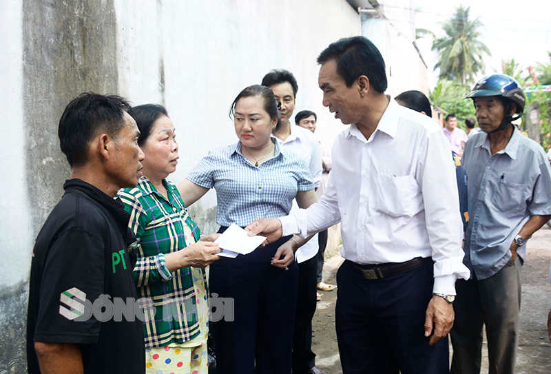 Trao tiền hỗ trợ của UBND huyện 5 triệu đồng cho gia đình anh Lê Nguyên Bá.